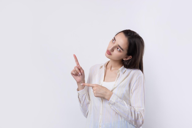 Szczęśliwa młoda kaukaska kobieta wskazuje palcami daleko od koszuli