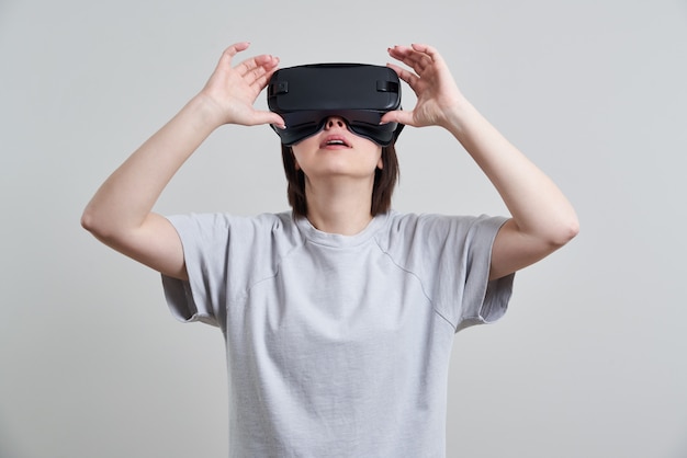 Szczęśliwa młoda kobieta bawić się na VR szkłach salowych, rzeczywistości wirtualnej pojęcie z młodą kobietą ma zabawę z słuchawki gogle z kopii przestrzenią