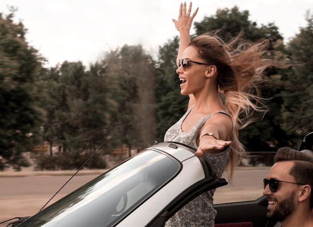 Szczęśliwa młoda kobieta ciesząca się jazdą kabrioletem