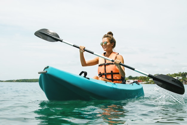 Szczęśliwa młoda kobieta kayaking na jeziorze