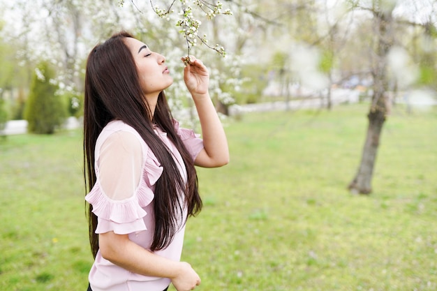 szczęśliwa młoda kobieta korzystających zapach w kwitnącym ogrodzie