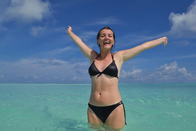 Szczęśliwa młoda kobieta na letnich wakacjach na pięknej tropikalnej plaży bawcie się cieszcie się i zrelaksować