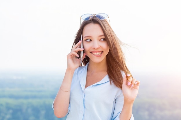 Szczęśliwa młoda kobieta rozmawia przez telefon i szczęśliwa