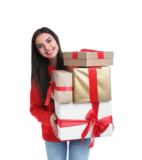 Szczęśliwa młoda kobieta trzyma prezenty świąteczne na białym tle
