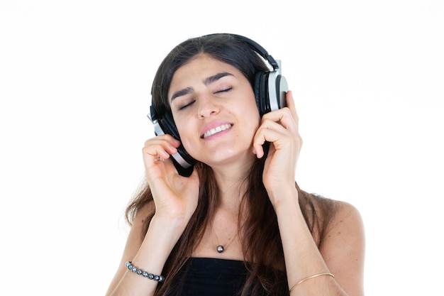 Szczęśliwa młoda kobieta uśmiech ze słuchawkami na głowie zamknięte oczy pozytywne emocjonalne na białym tle