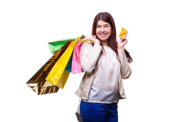 Szczęśliwa młoda kobieta z torbami na zakupy i kartą kredytową