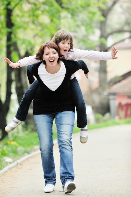 szczęśliwa młoda matka i córka bawią się na świeżym powietrzu