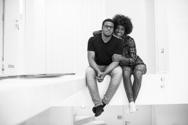 Szczęśliwa młoda para Afroamerykanów mająca przerwę podczas przeprowadzki do nowego domu