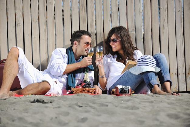 szczęśliwa młoda para cieszy się piknikiem na plaży i dobrze się bawi na letnich wakacjach