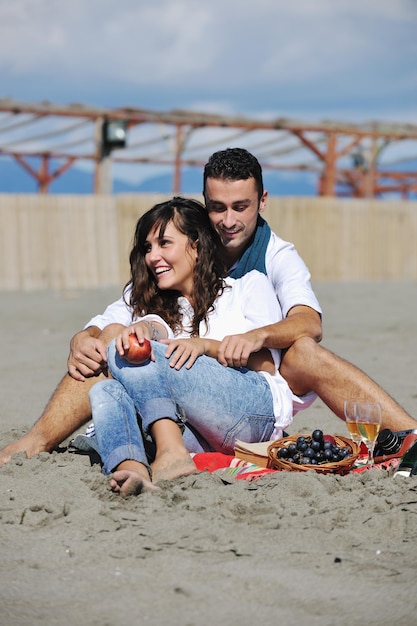 szczęśliwa młoda para cieszy się piknikiem na plaży i dobrze się bawi na letnich wakacjach