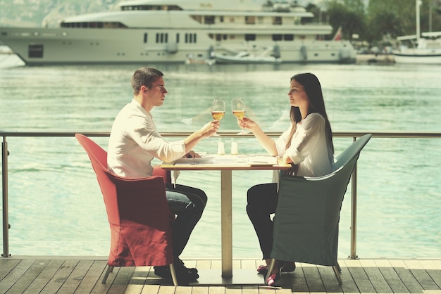 szczęśliwa młoda para mająca lancz w pięknej restauracji nad morzem na plaży