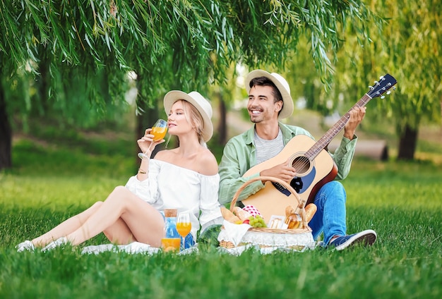 Szczęśliwa młoda para na pikniku w parku