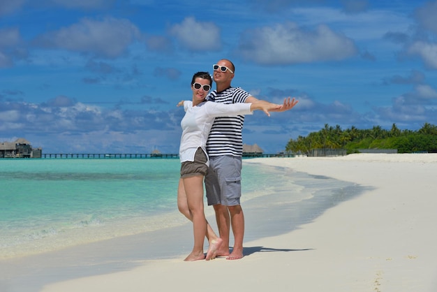 szczęśliwa młoda para na wakacjach bawi się i relaksuje w piękny słoneczny dzień na plaży