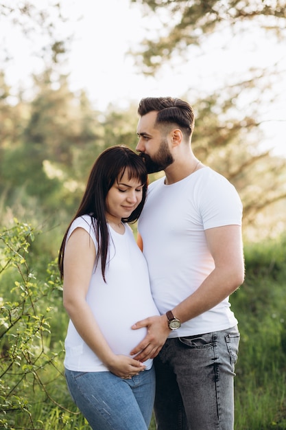 Szczęśliwa młoda para spodziewa się dziecka w parku latem