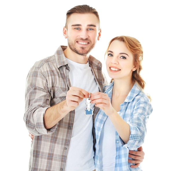 Zdjęcie szczęśliwa młoda para z kluczami z nowego domu na białym tle