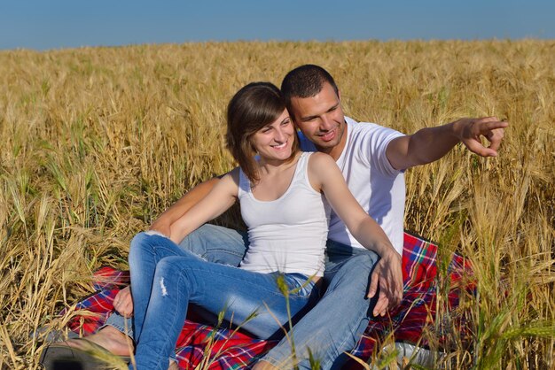 szczęśliwa młoda para zakochana ma romans i zabawę na polu pszenicy w lecie