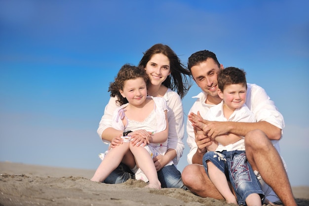 szczęśliwa młoda rodzina bawi się i prowadzi zdrowy tryb życia na plaży