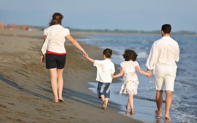 szczęśliwa młoda rodzina bawi się i prowadzi zdrowy tryb życia na plaży