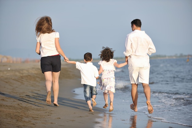 szczęśliwa młoda rodzina bawi się i prowadzi zdrowy tryb życia na plaży