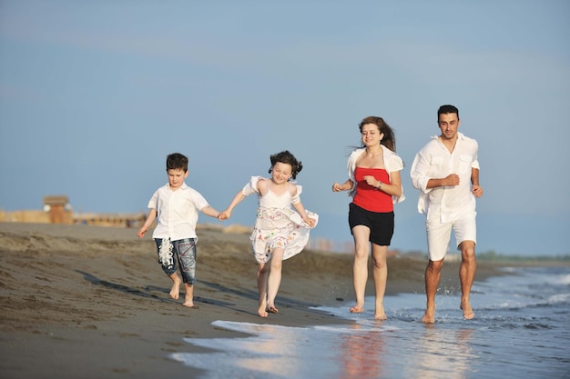 szczęśliwa młoda rodzina bawi się i prowadzi zdrowy tryb życia na plaży