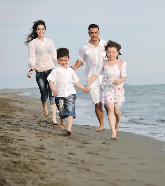 Szczęśliwa Młoda Rodzina Bawi Się I Prowadzi Zdrowy Tryb życia Na Plaży