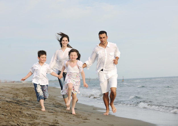 szczęśliwa młoda rodzina bawi się i prowadzi zdrowy tryb życia na plaży