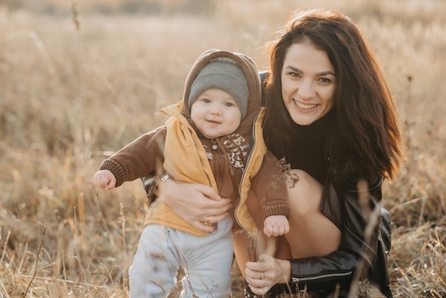 Szczęśliwa młoda rodzina na spacer jesienią, mama z synkiem