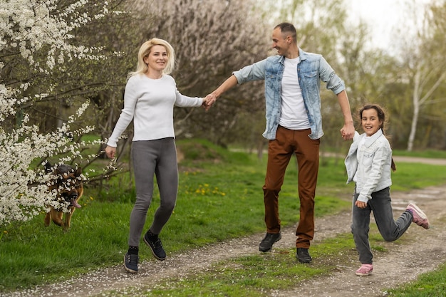 Szczęśliwa młoda rodzina spędza czas na zewnątrz w zielonej naturze