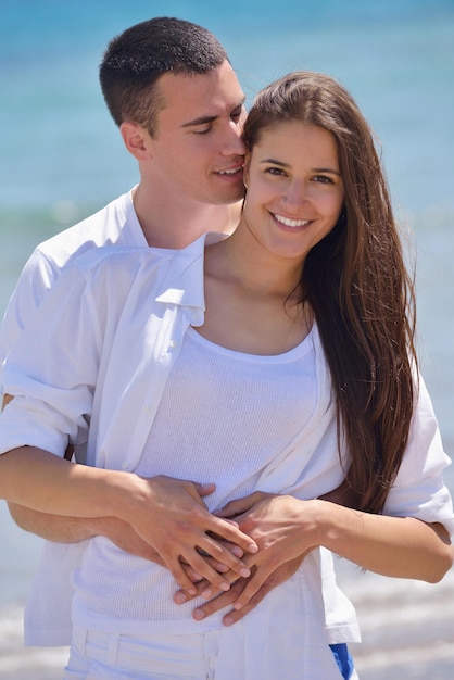 szczęśliwa młoda romantyczna para zakochana bawi się biegając i relaksując się na pięknej plaży