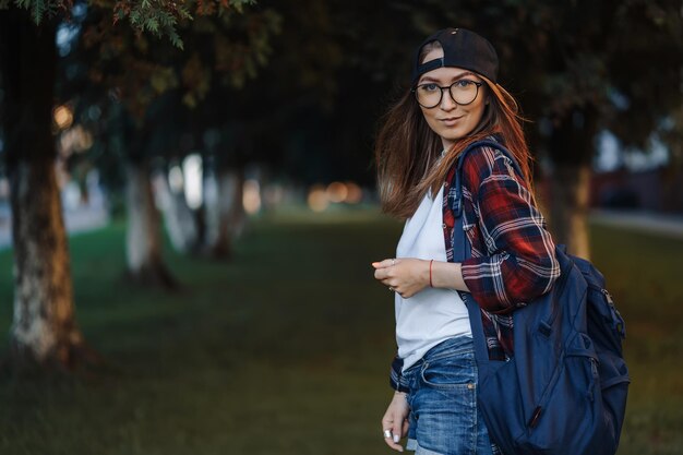 Zdjęcie szczęśliwa młoda studentka ubrana w zwykłe ubrania z filiżanką kawy