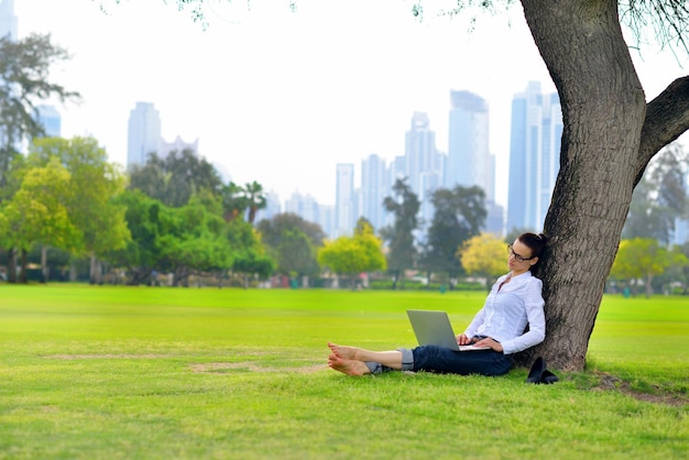szczęśliwa młoda studentka z laptopem w studium parku miejskiego