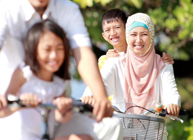 Szczęśliwa muzułmańska rodzina jedzie na rowerach