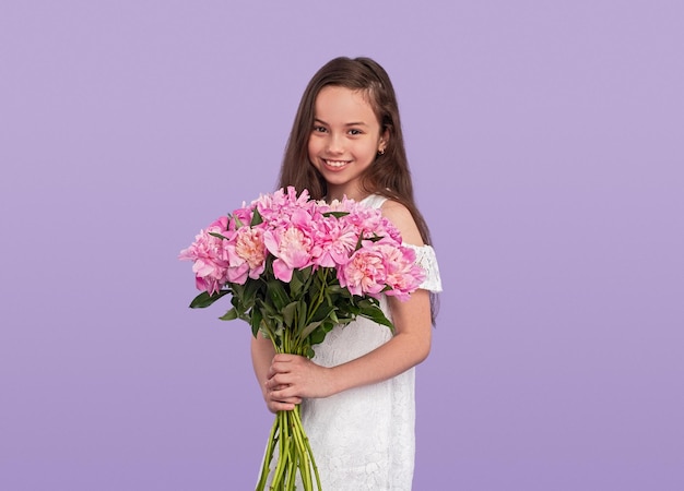 Szczęśliwa nastolatka w peruce niosąca kwiaty