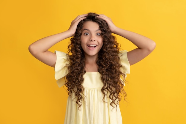 Szczęśliwa nastolatka z długimi kręconymi włosami i idealną skórą wyraża szczęście zdrowe włosy