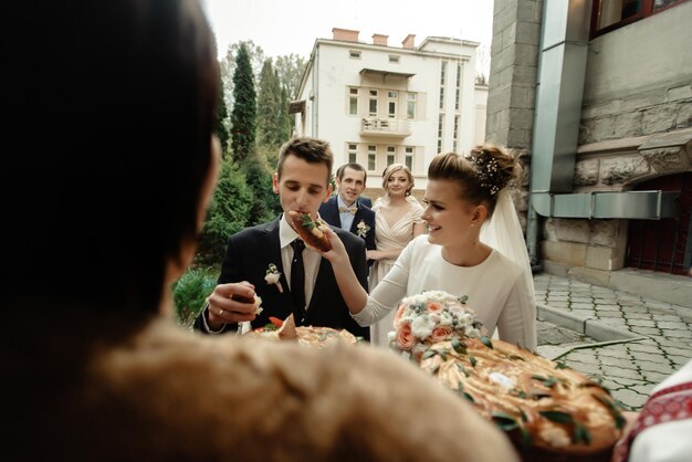 Szczęśliwa panna młoda i pan młody degustacja tortu i śmiejący się zabawny moment prawdziwe emocje wspaniały ślub