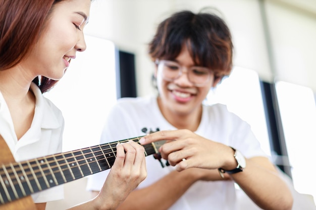 Szczęśliwa Para I Aktywność Domowa Młody Człowiek Uczy Dziewczynę Grającą Na Gitarze W Salonie