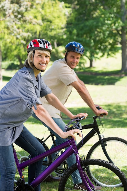 Szczęśliwa para jazda na rowerze w parku