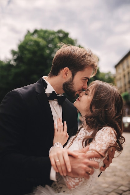 Szczęśliwa para nowożeńców przytulanie i całowanie w starej europejskiej ulicy miasta