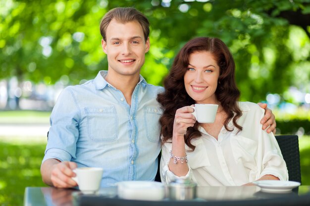 Szczęśliwa para pije cappuccino outdoors