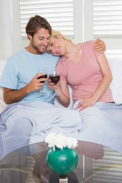 Szczęśliwa para pije czerwone wino wpólnie na leżance