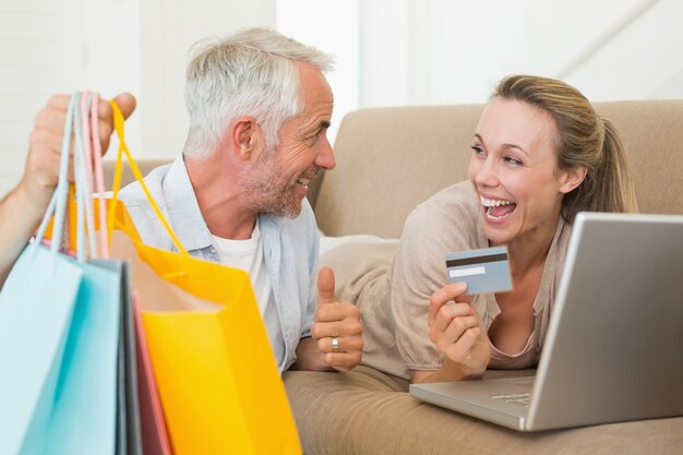 Szczęśliwa para robi zakupy online na leżance