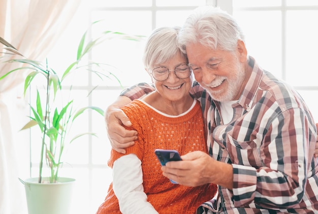 Szczęśliwa para seniorów komunikująca się zdalnie z krewnymi i przyjaciółmi Dziadkowie ze smartfonami oddalenie i koncepcje komunikacji technologicznej