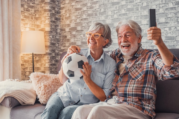 Szczęśliwa para seniorów lub fanów piłki nożnej oglądających piłkę nożną w telewizji i świętujących zwycięstwo w domu Koncepcja sportu i rozrywki rodzinnej xA