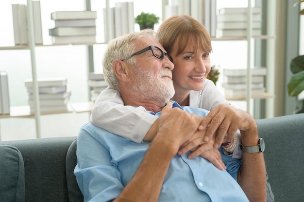 Zdjęcie szczęśliwa para seniorów rasy kaukaskiej relaks w salonie w domu