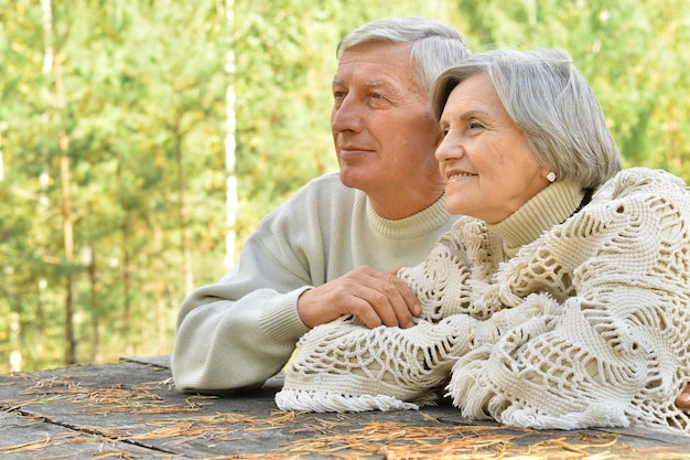 Szczęśliwa para seniorów w jesiennym parku przytulającym