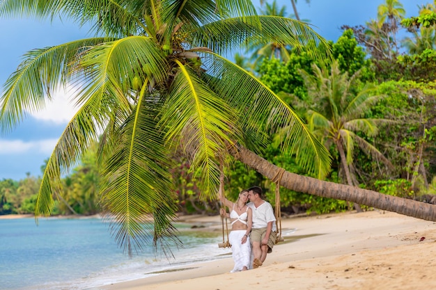 Szczęśliwa para siedzi na słonecznej plaży