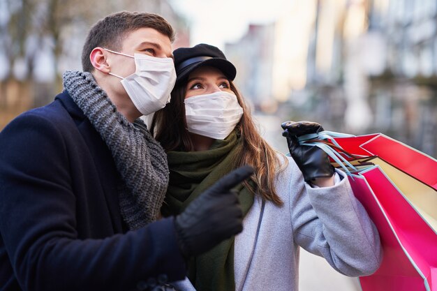 Szczęśliwa para świętująca Walentynki w maskach podczas pandemii covid-19 w mieście