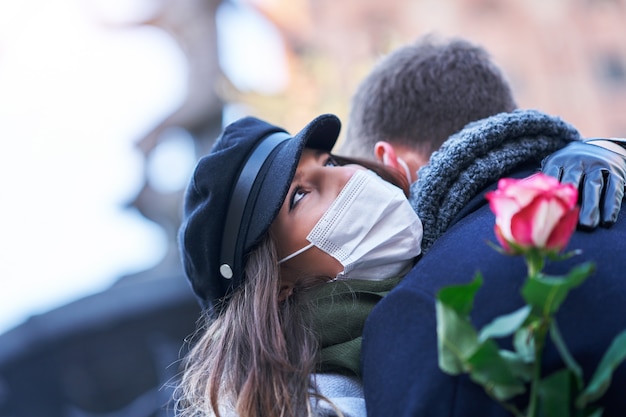 Szczęśliwa para świętująca Walentynki w maskach podczas pandemii covid-19 w mieście