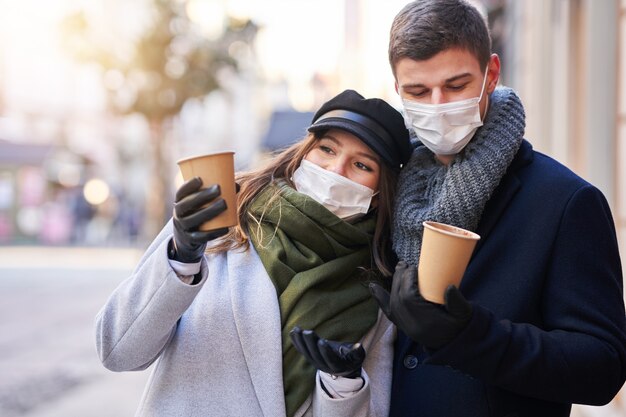 Szczęśliwa para świętująca Walentynki w maskach podczas pandemii covid-19 w mieście