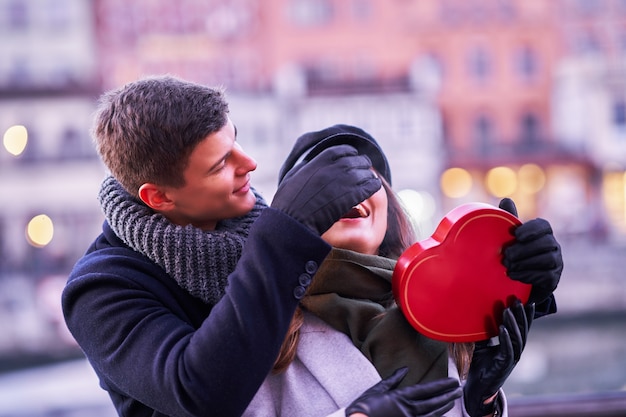 Zdjęcie szczęśliwa para świętująca walentynki w maskach podczas pandemii covid-19 w mieście